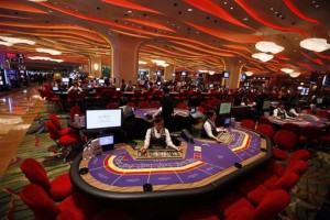In this Sept. 20, 2012 photo, Croupiers sit at a baccarat gaming table inside a casino during the opening day of Sheraton Macao Hotel at the Sands Cotai Central in Macau. Macau is in the midst of one of the greatest gambling booms the world has ever known. To rival it, Las Vegas would have to attract six times as many visitors essentially every man, woman and child in America. Wynn Las Vegas now makes nearly three-quarters of its profits in Macau. Sands, which owns the Venetian and Palazzo, earns two-thirds of its revenue there. (AP Photo/Kin Cheung)